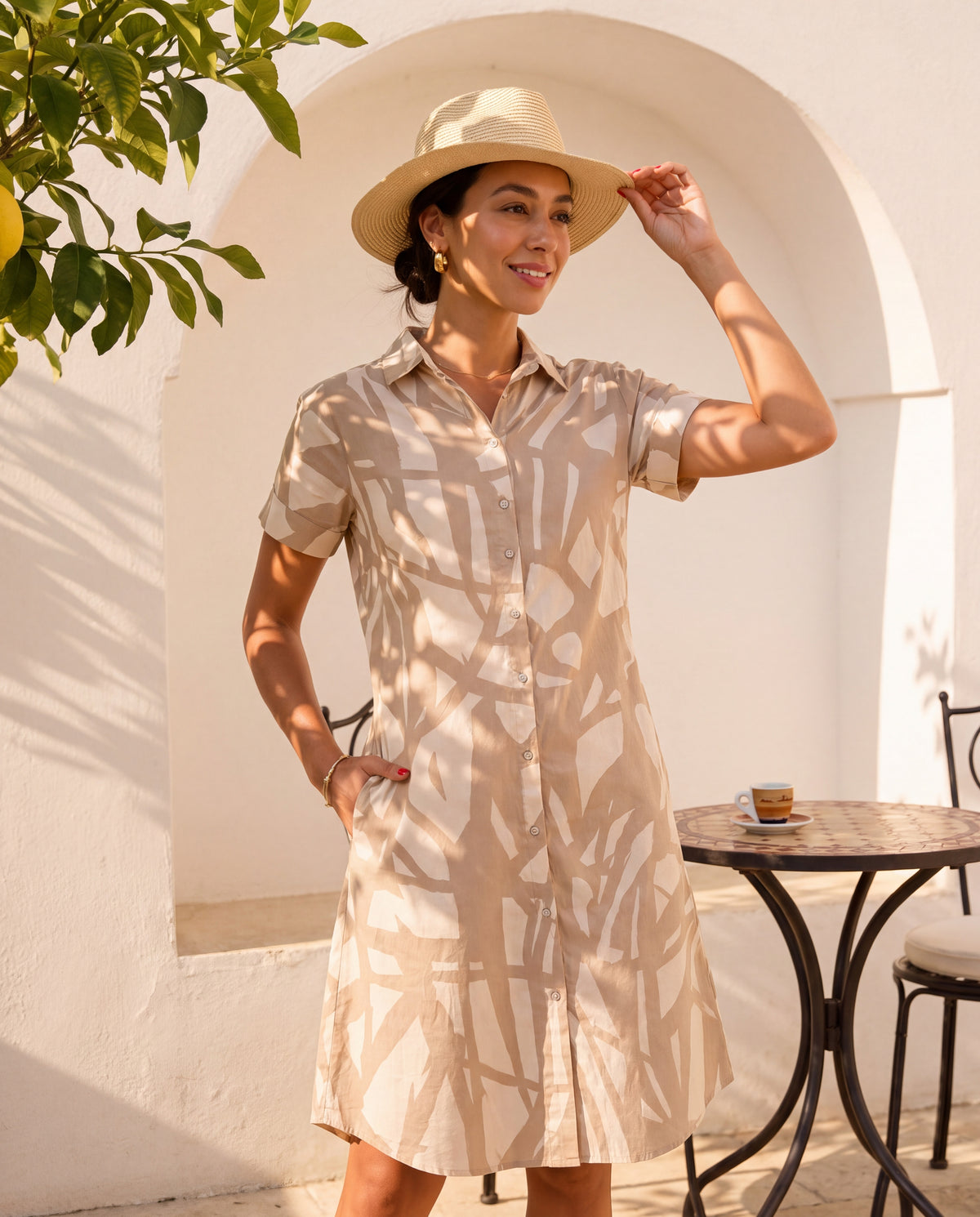 The Sorrento Shirt Dress in Sabbia, styled with a straw hat